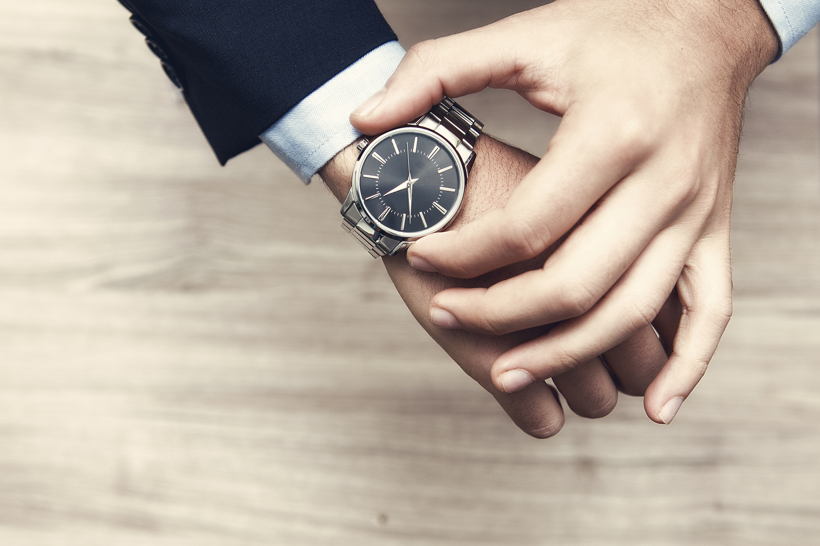 mano di uomo con al polso orologio, con camicia e giacca elegante per lavoro