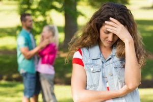Angry woman with man and girlfriend in background at park