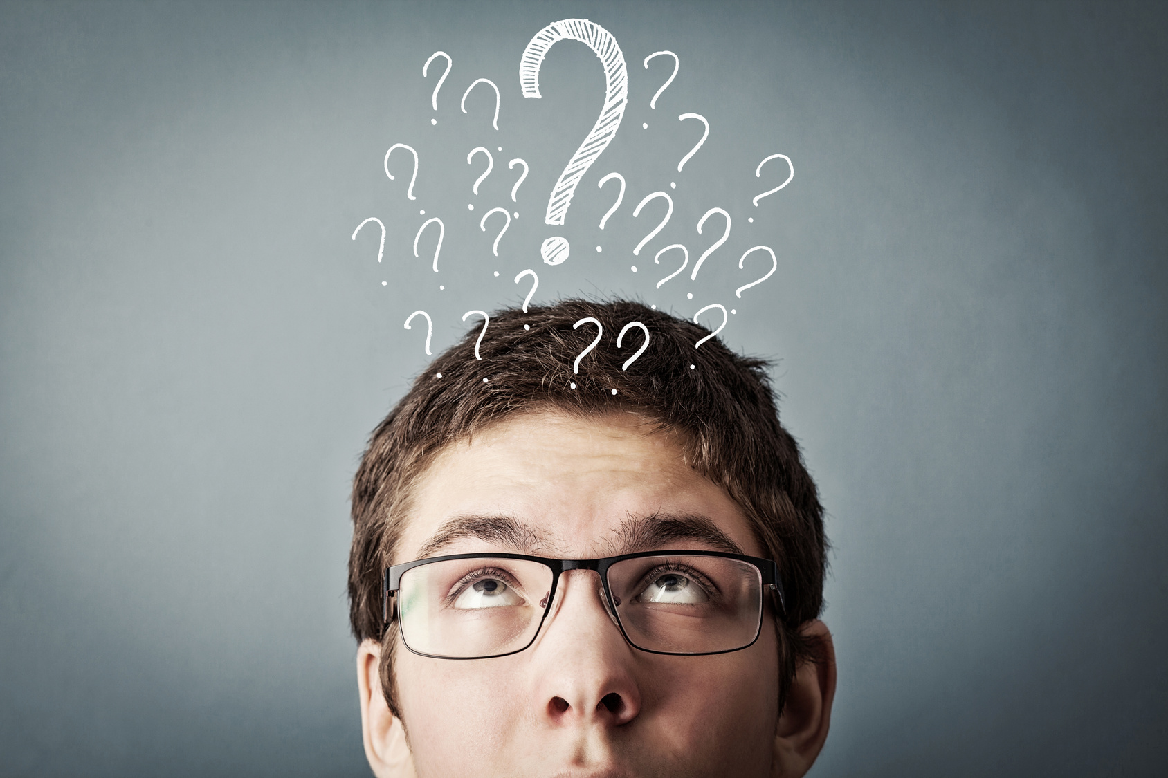 thinking teen with many question marks above his head