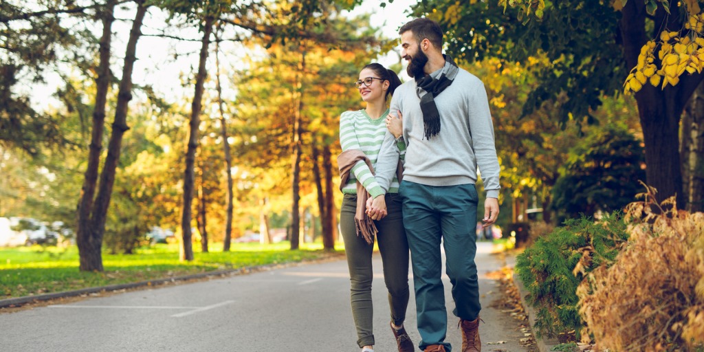 romantic-couple-enjoying-a-walk-in-an-autumn-park-picture-id862297874