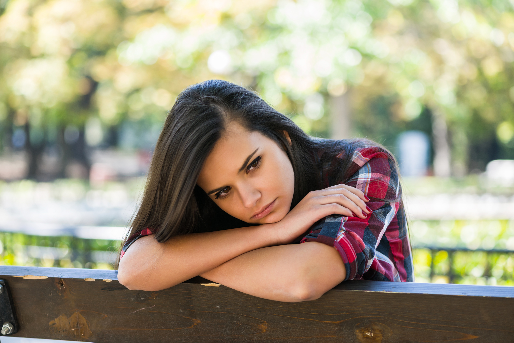 Unhappy girl sitting at bench