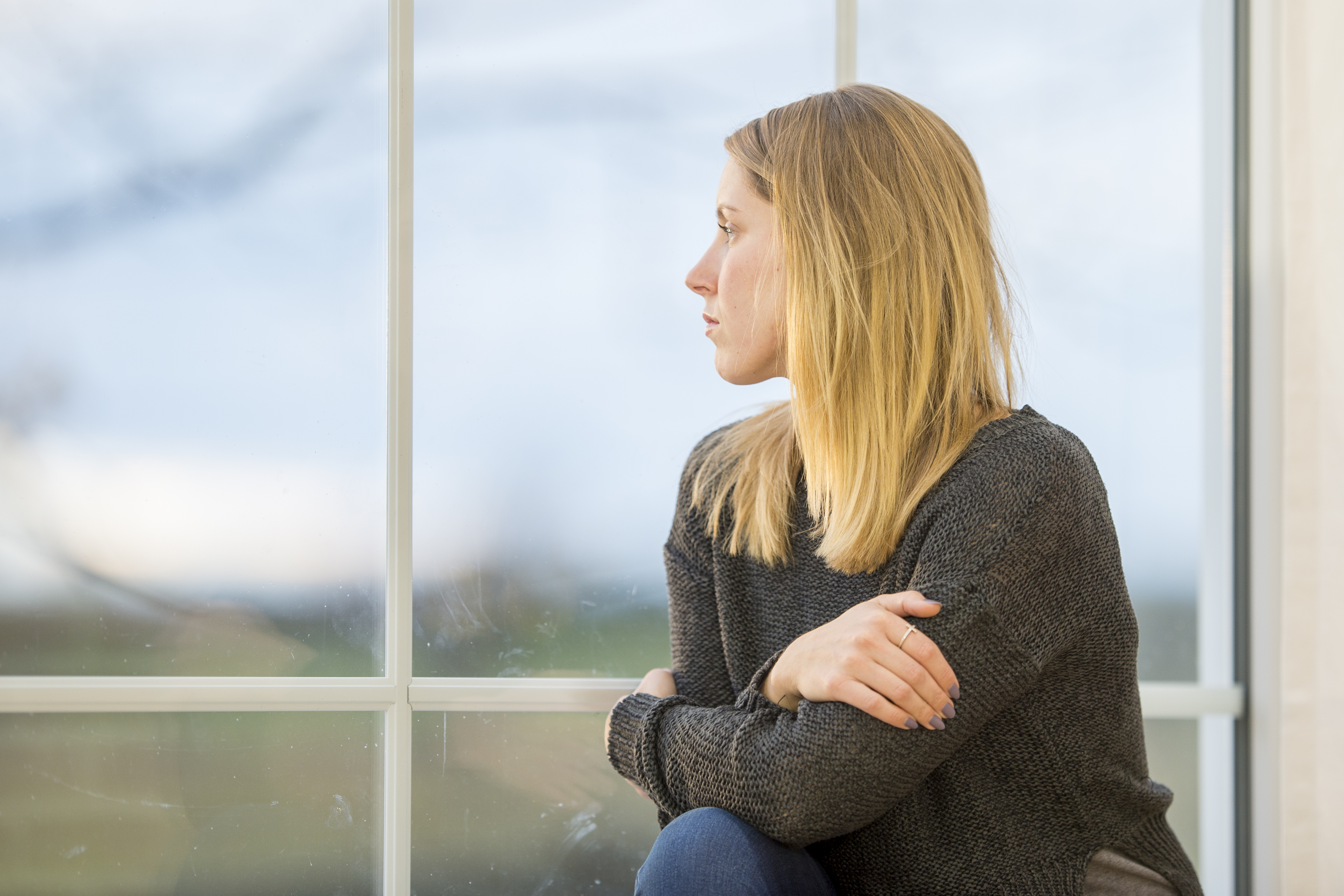 Young woman looks out the window pensively