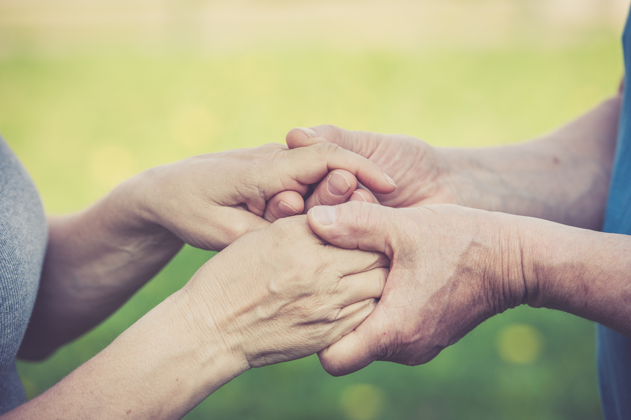 Holding hands with green spring background