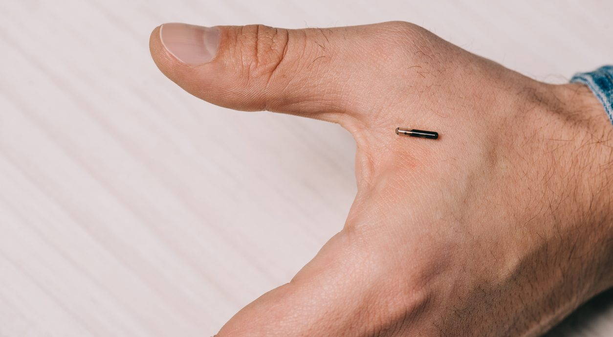 cropped view of male hand with microchip on table