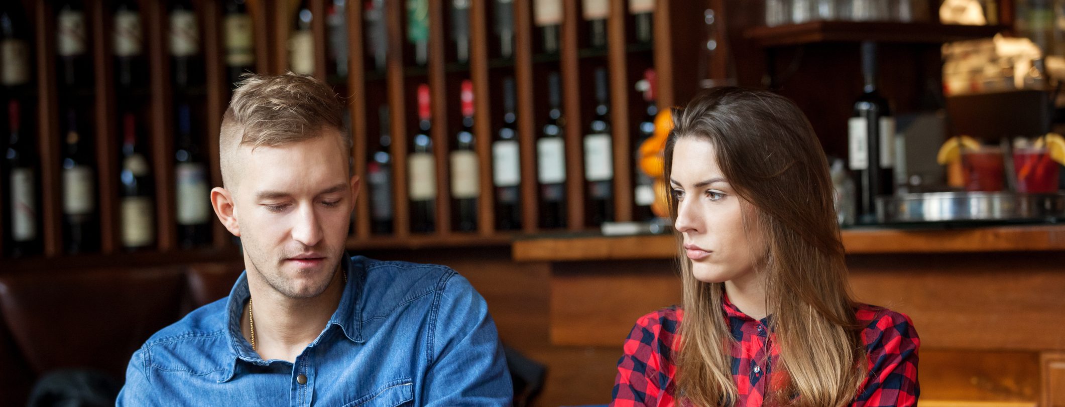 Man hiding text messages while woman is sulking