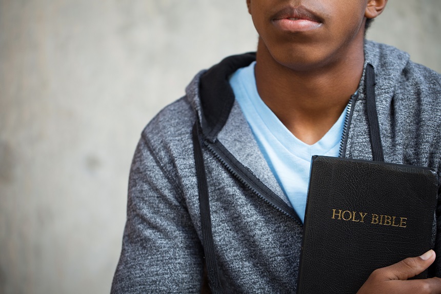 Teenage boy holding a Bible.