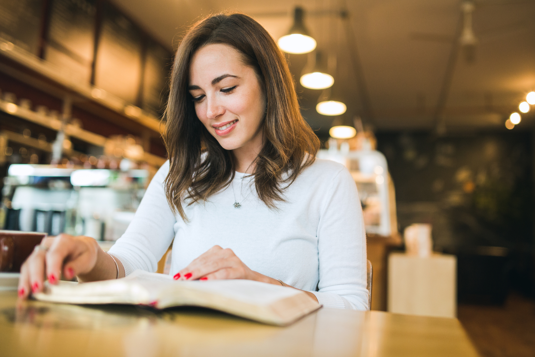 Woman Reading Book in Coffee Shop