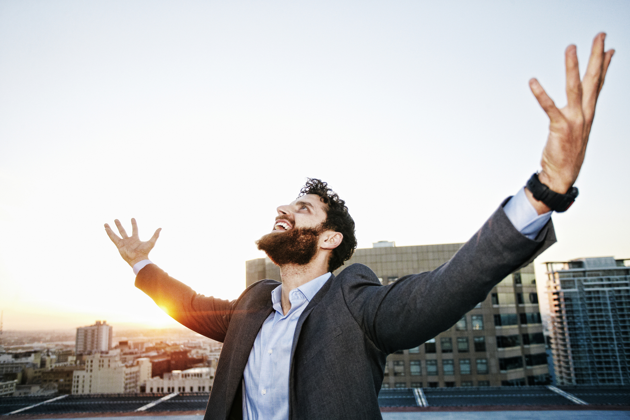 Caucasian businessman celebrating on urban rooftop