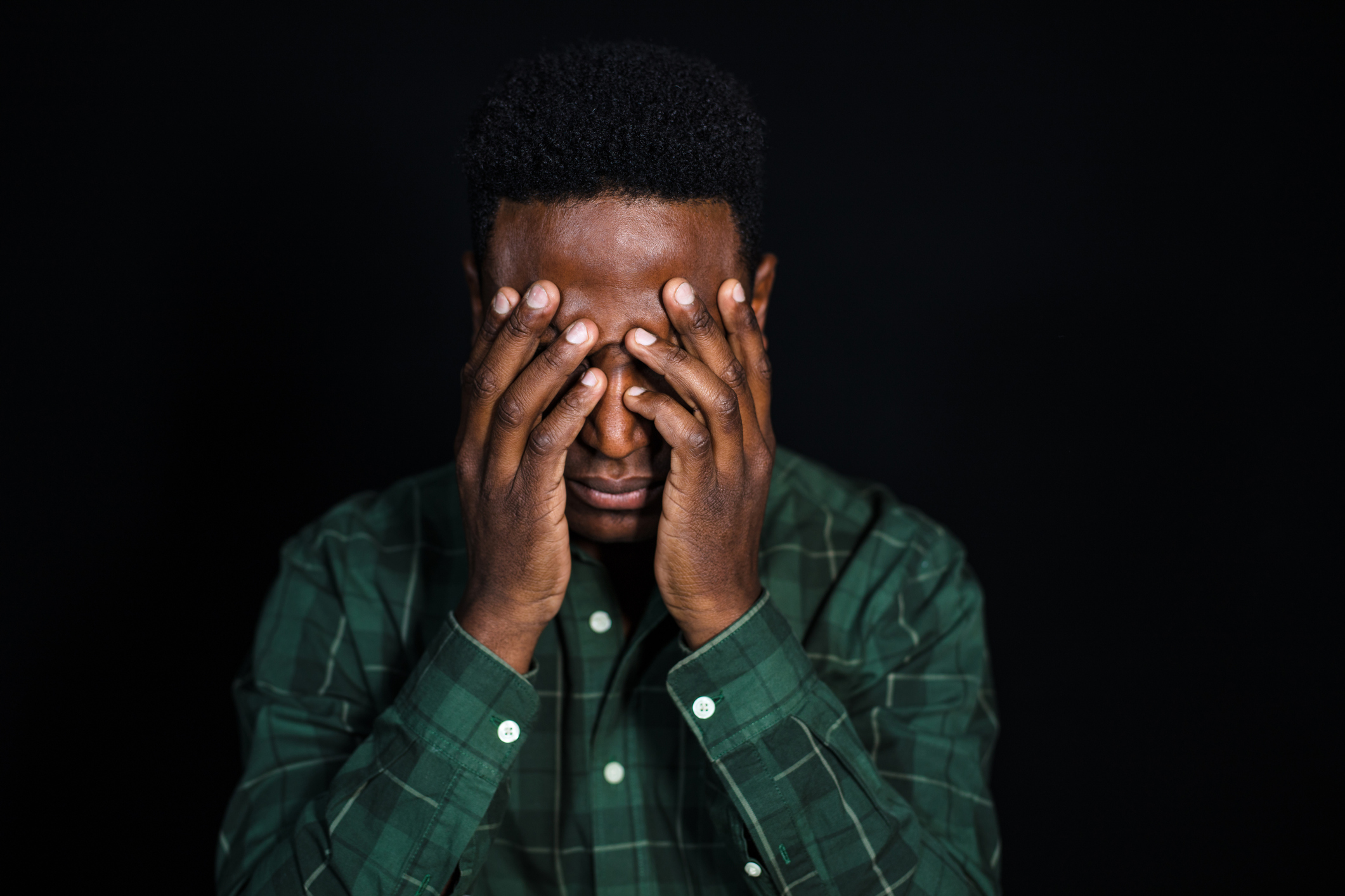 Stressed african man on black background
