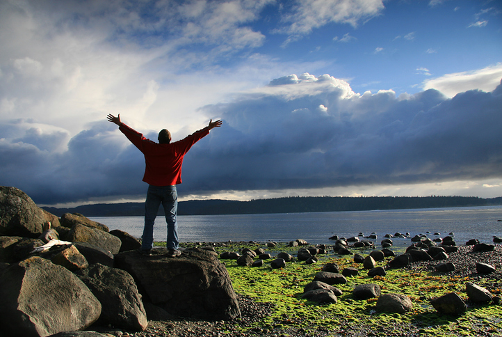 Man Raising His Hands to Heaven in Beautiful Ocean Setting