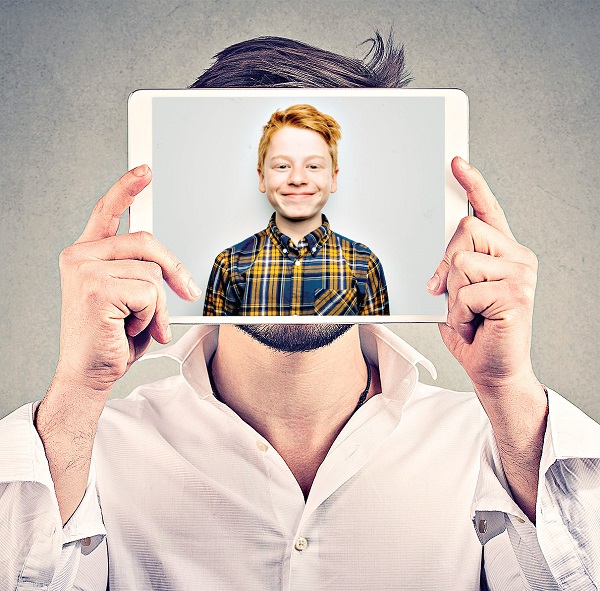 Anonymous man covering face with tablet computer