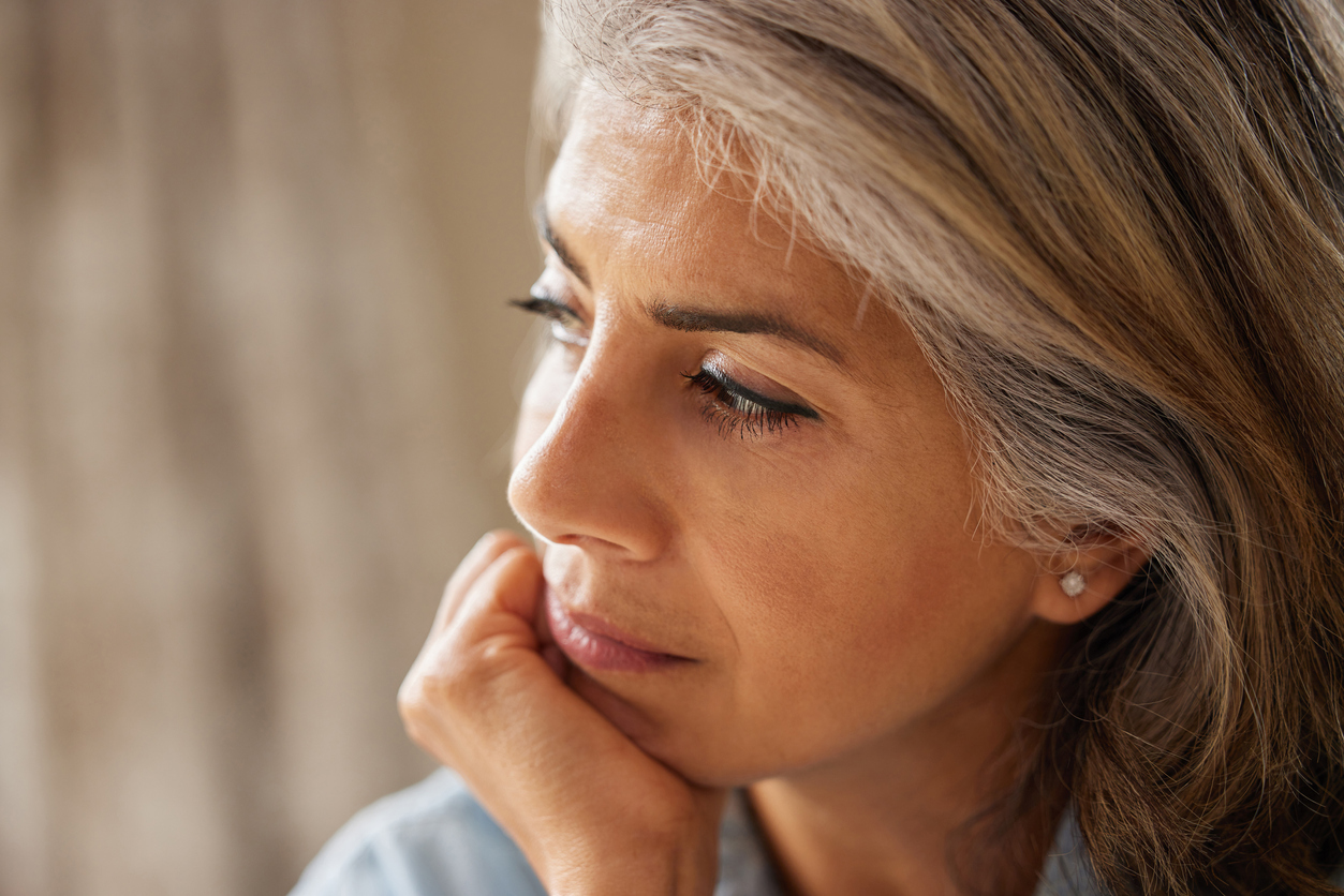 Close Up Shot Of Thoughtful Mature Woman Looking Out Of Window At Home