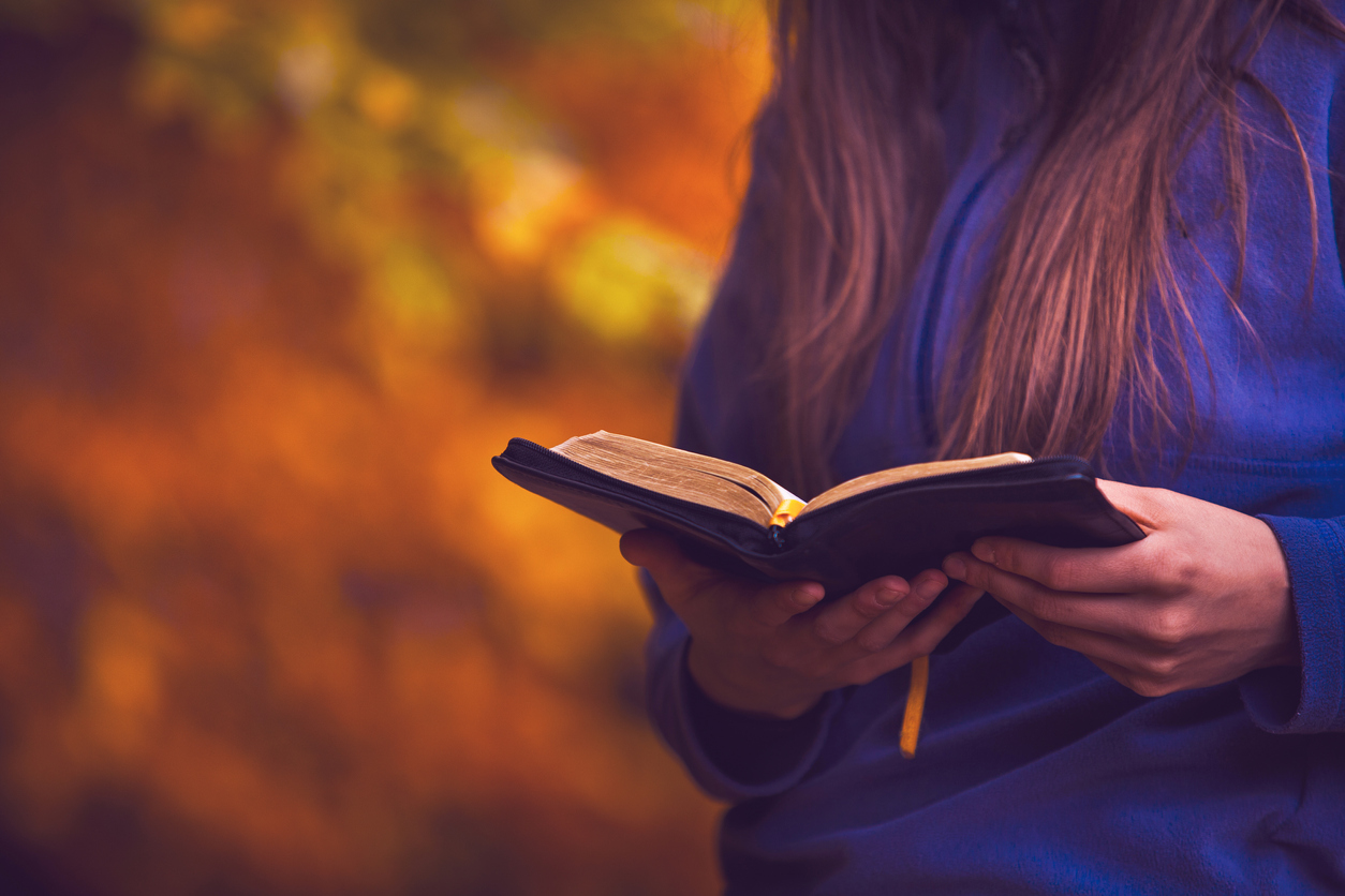 Autumn setting, warm colours, girl reading the bible