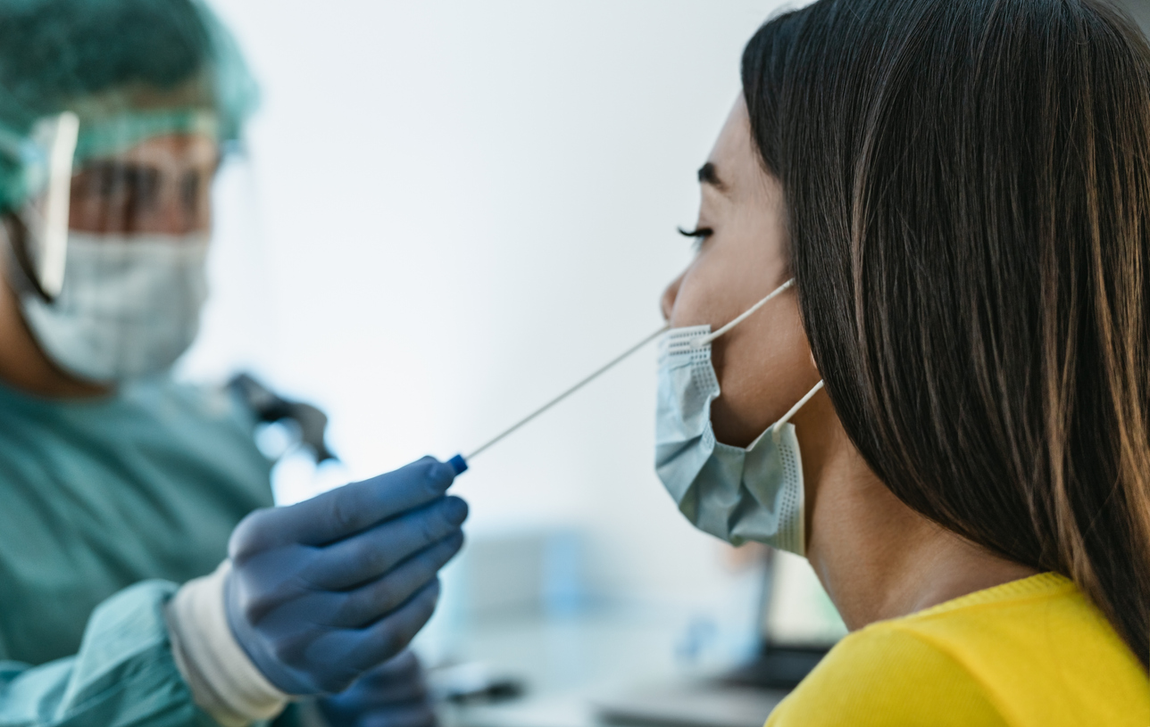 Medical worker wearing personal protective equipment doing corona virus swab on female patient &#8211; Covid19 test and health care concept