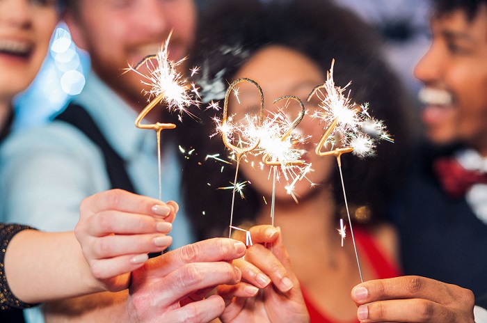Smiling people holding sparklers