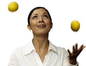 Asian woman juggling lemons in kitchen