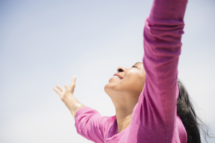 Mixed race woman with arms outstretched outdoors