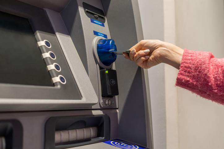 Young woman inserting her bank card