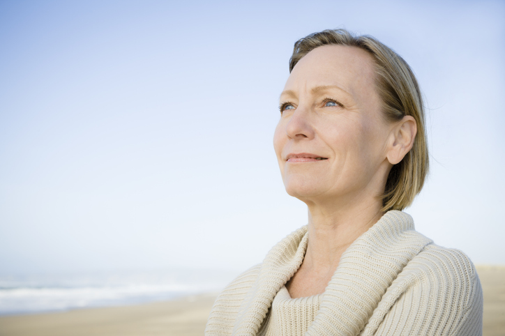 Smiling Caucasian woman standing on beach