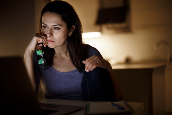 Woman working on laptop late at home