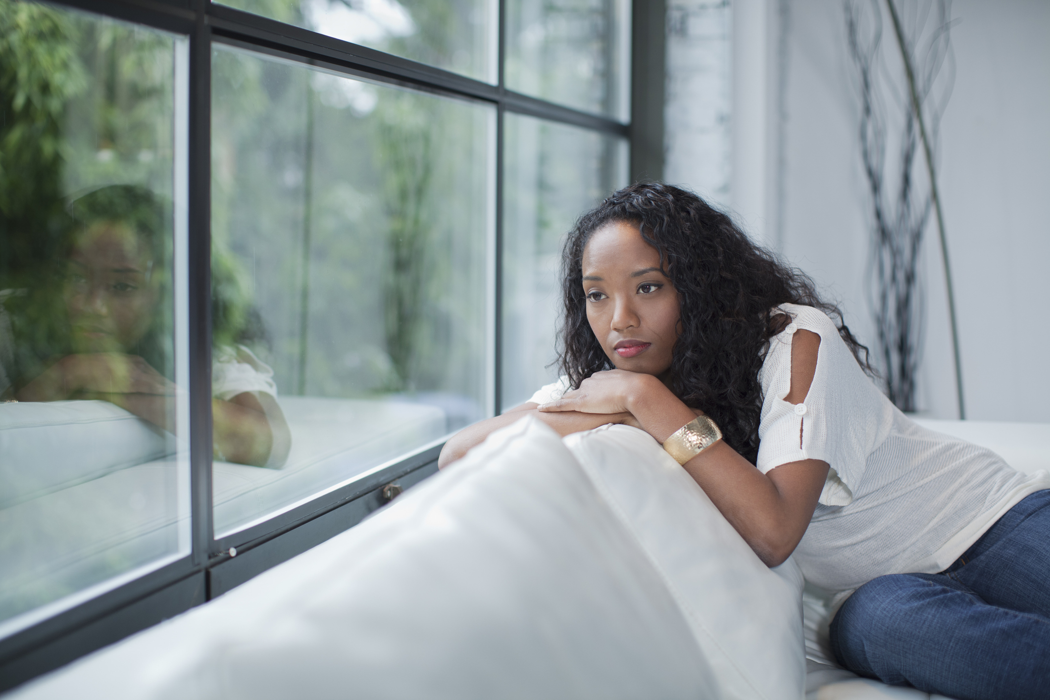 Serious mixed race woman looking out window