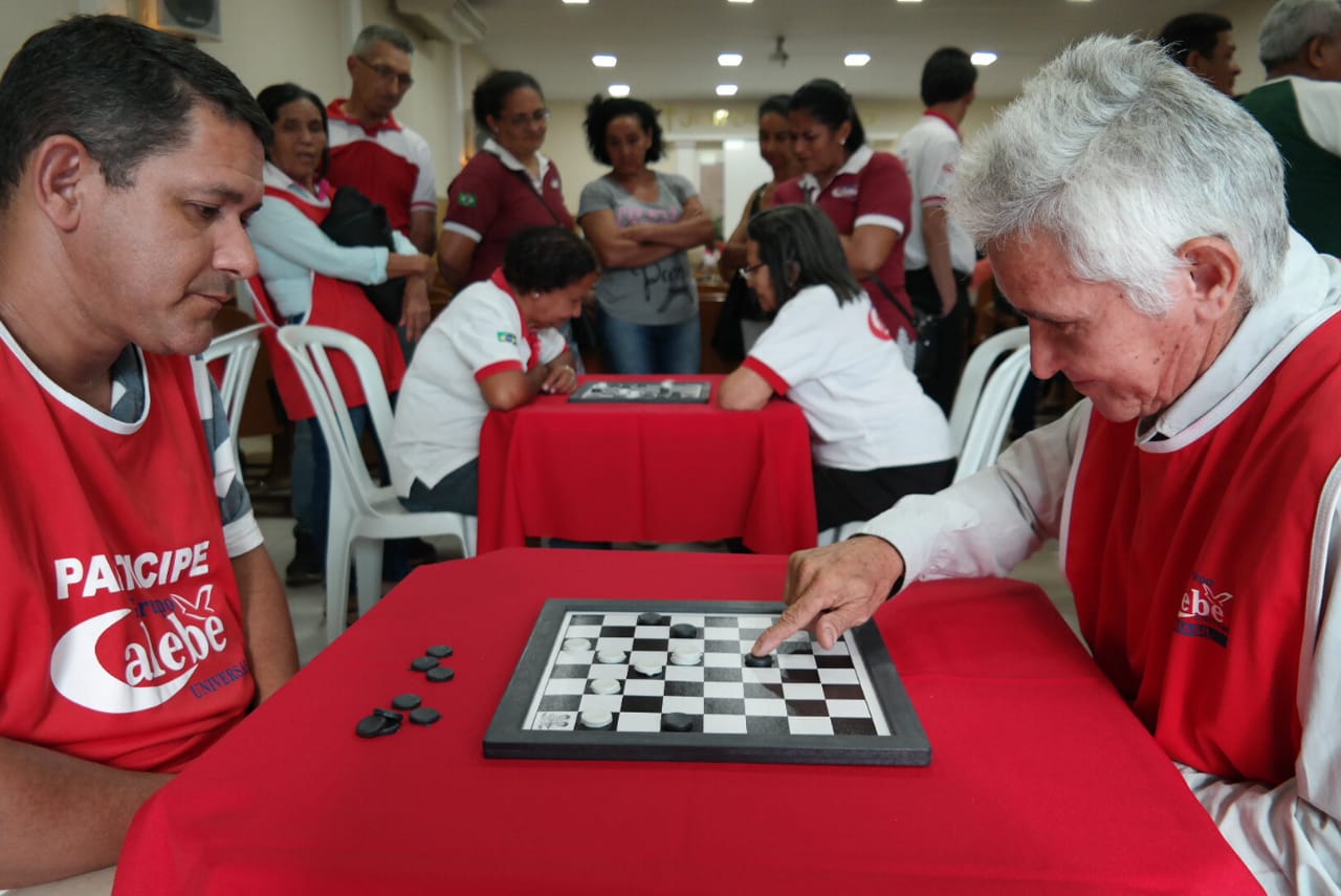 As pessoas estão jogando damas fechando o conceito de um jogo de tabuleiro