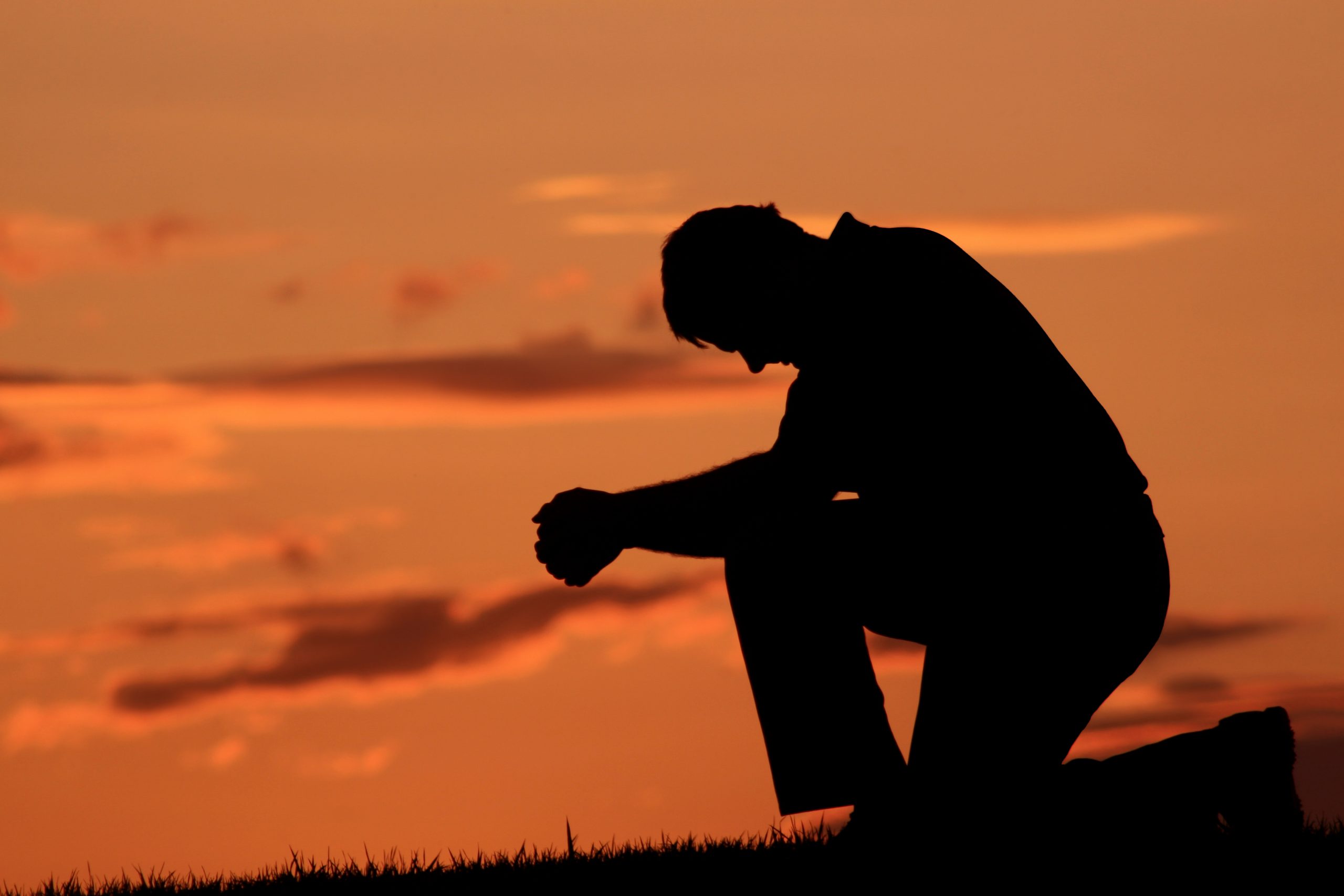 Silhouette of Middle Aged Male Saying A Prayer