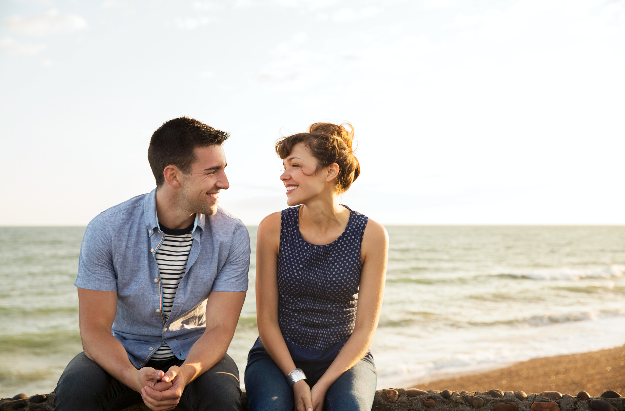 Man and woman sat on wall together