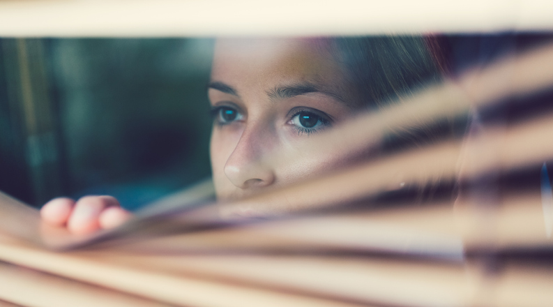 Unhappy woman looking through the window