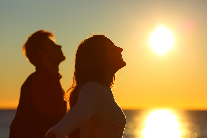 Silhouette of a couple of friends breathing at sunset