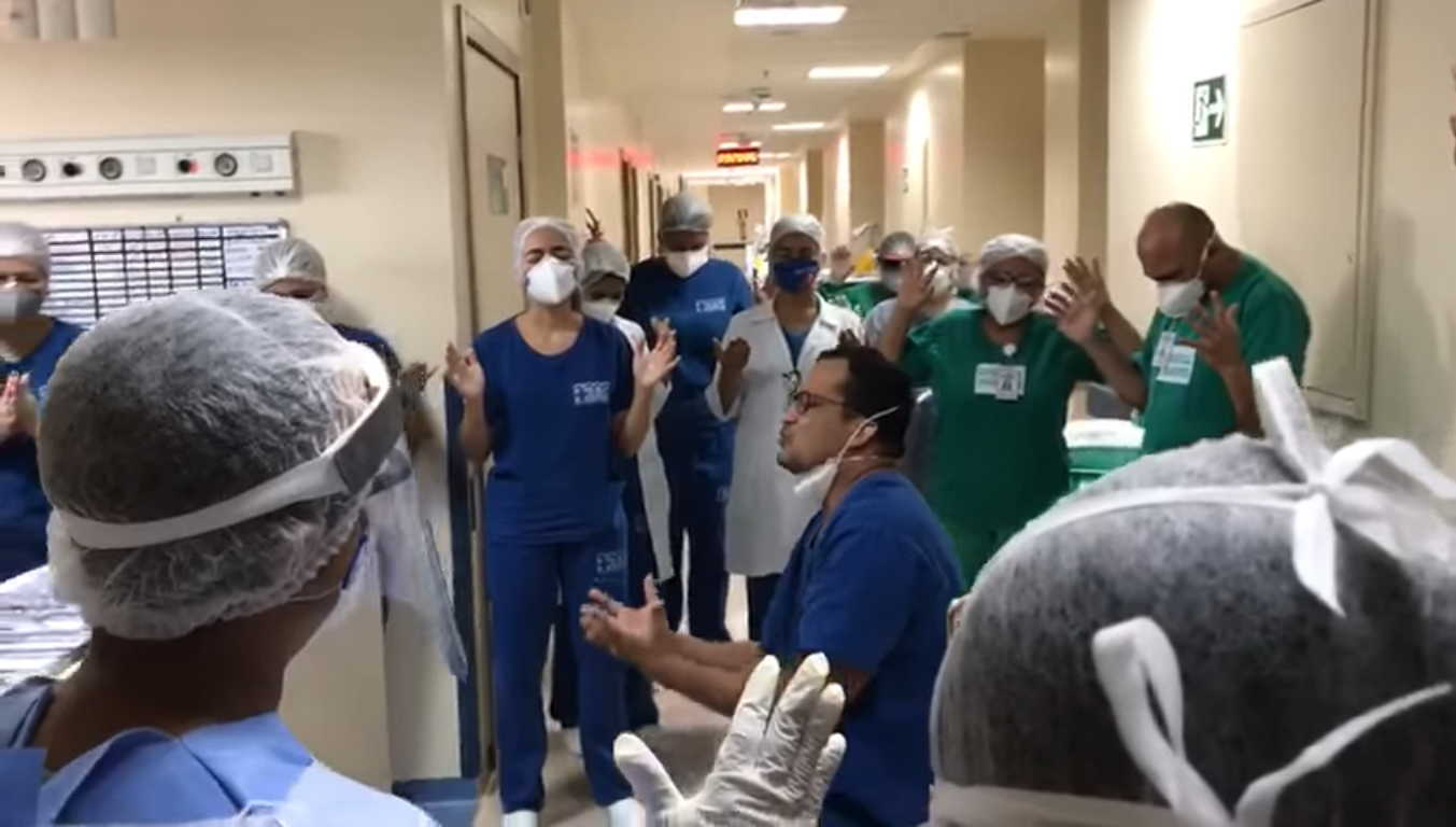 Médico ora com equipe em hospital