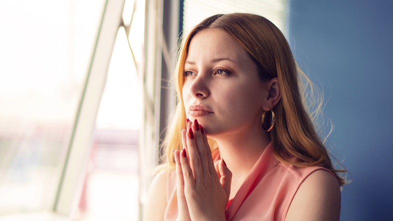 Attractive business woman praying in office