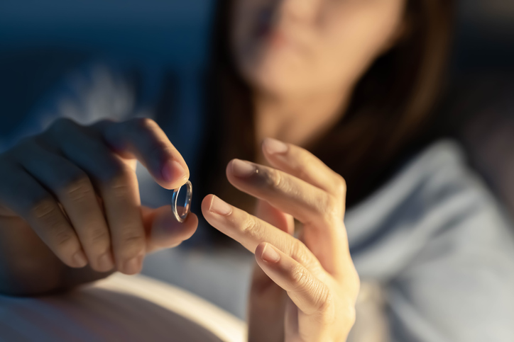 depressed woman hold wedding ring