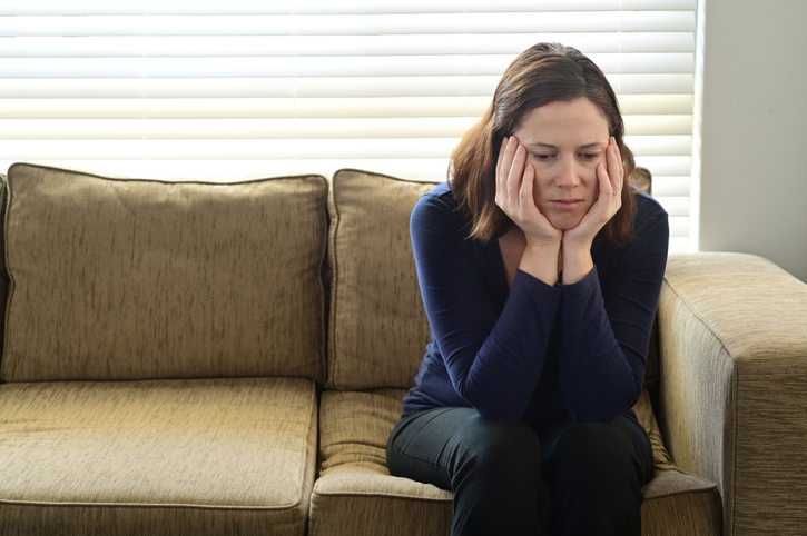 Sad adult woman forced to stay at home as the pandemic coronavirus (COVID-19) forces many people to stay at home because new government policies