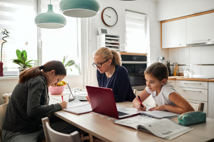 Homeschooling – Mother Helping To Her Daughters To Finish School Homework During Coronavirus Quarantine