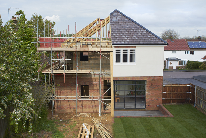 Composite of a modern house during and after construction.