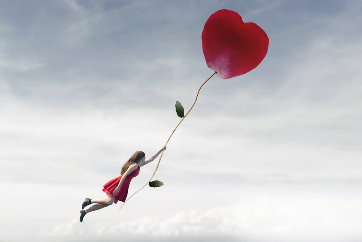 surreal woman flying free in the sky hanging from a red flower