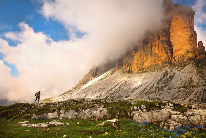 Hiker walk under the mountains Tre Cime di Lavaredo National Park, Dolomites, European Alps, Italy,