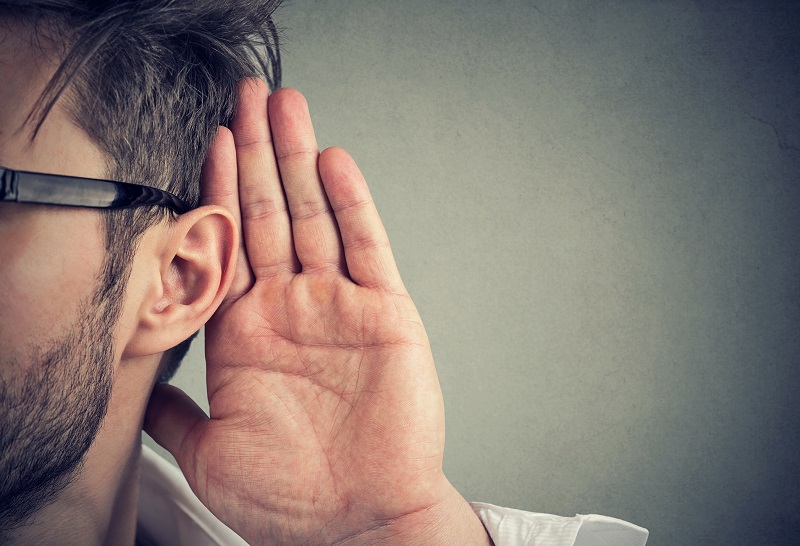 man holds his hand near ear and listens carefully