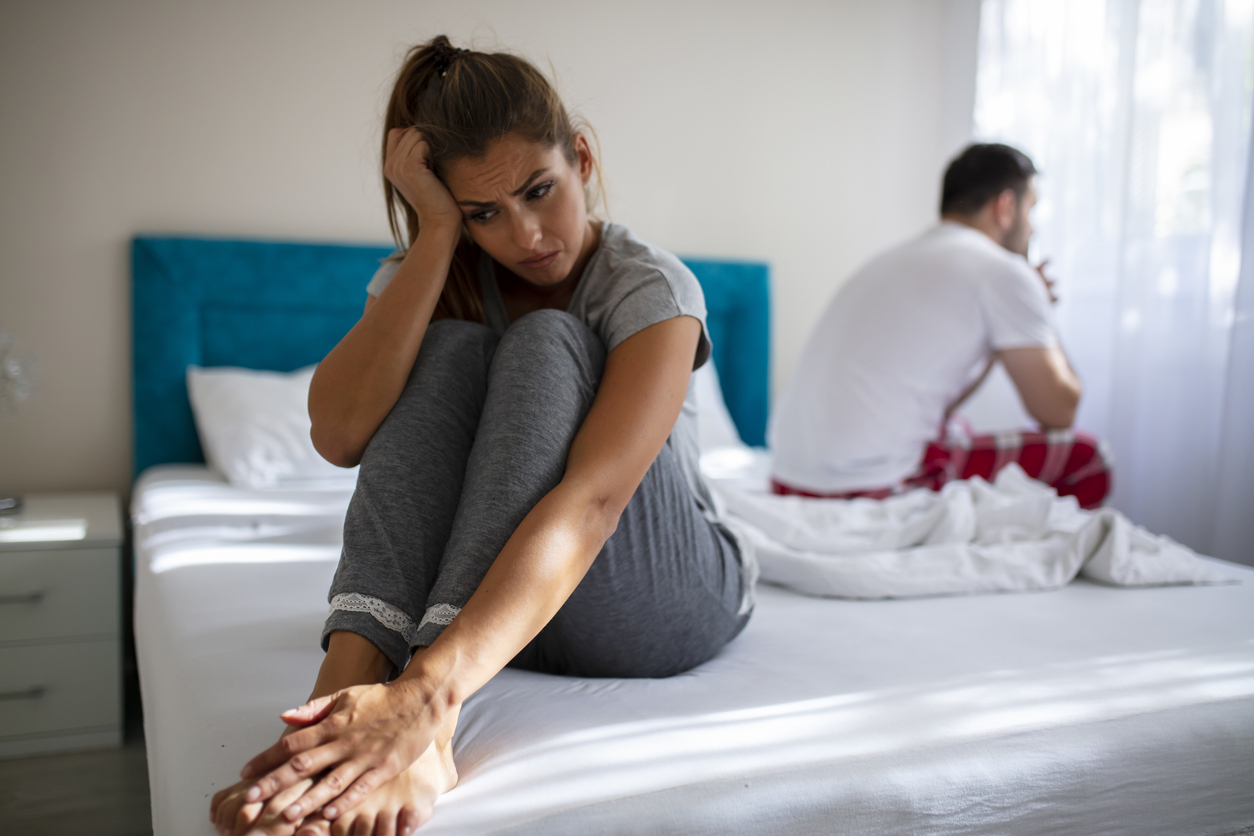 Couple in conflict standing sad in the bed.