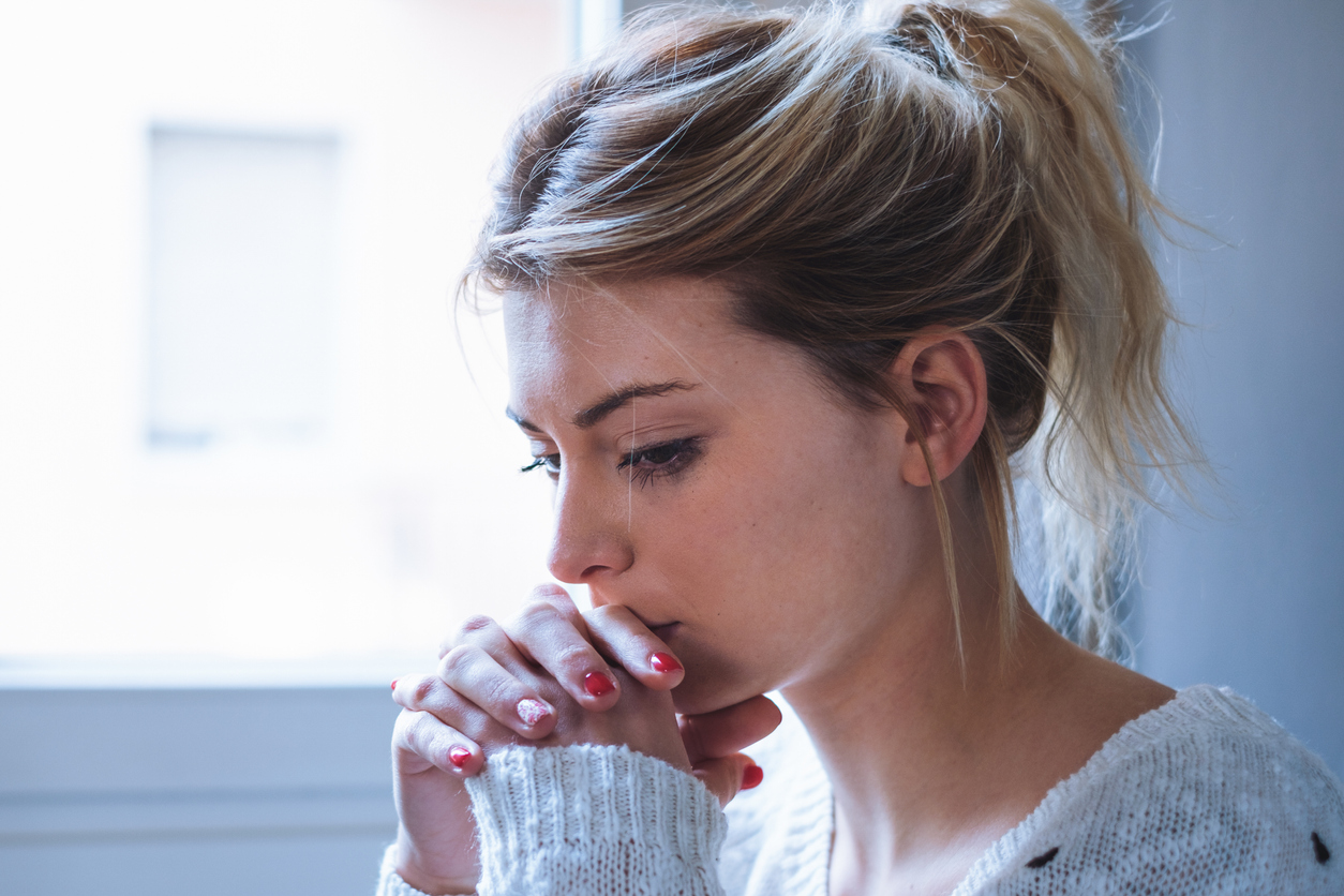 Worried and alone girl next to the window light