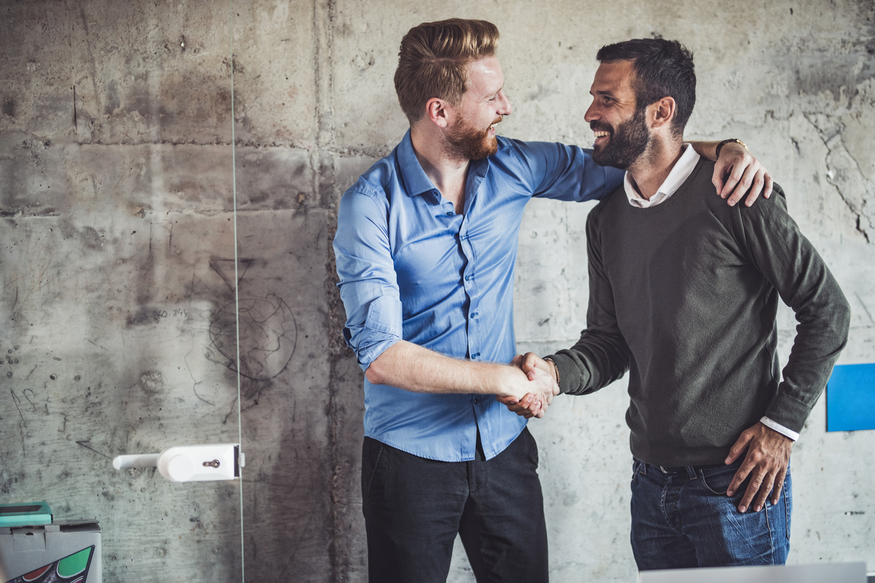 Happy businessmen greeting each other in the office.