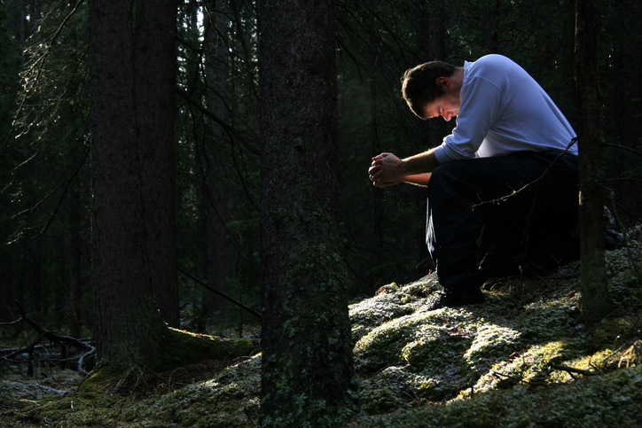 Man Praying in the Forest