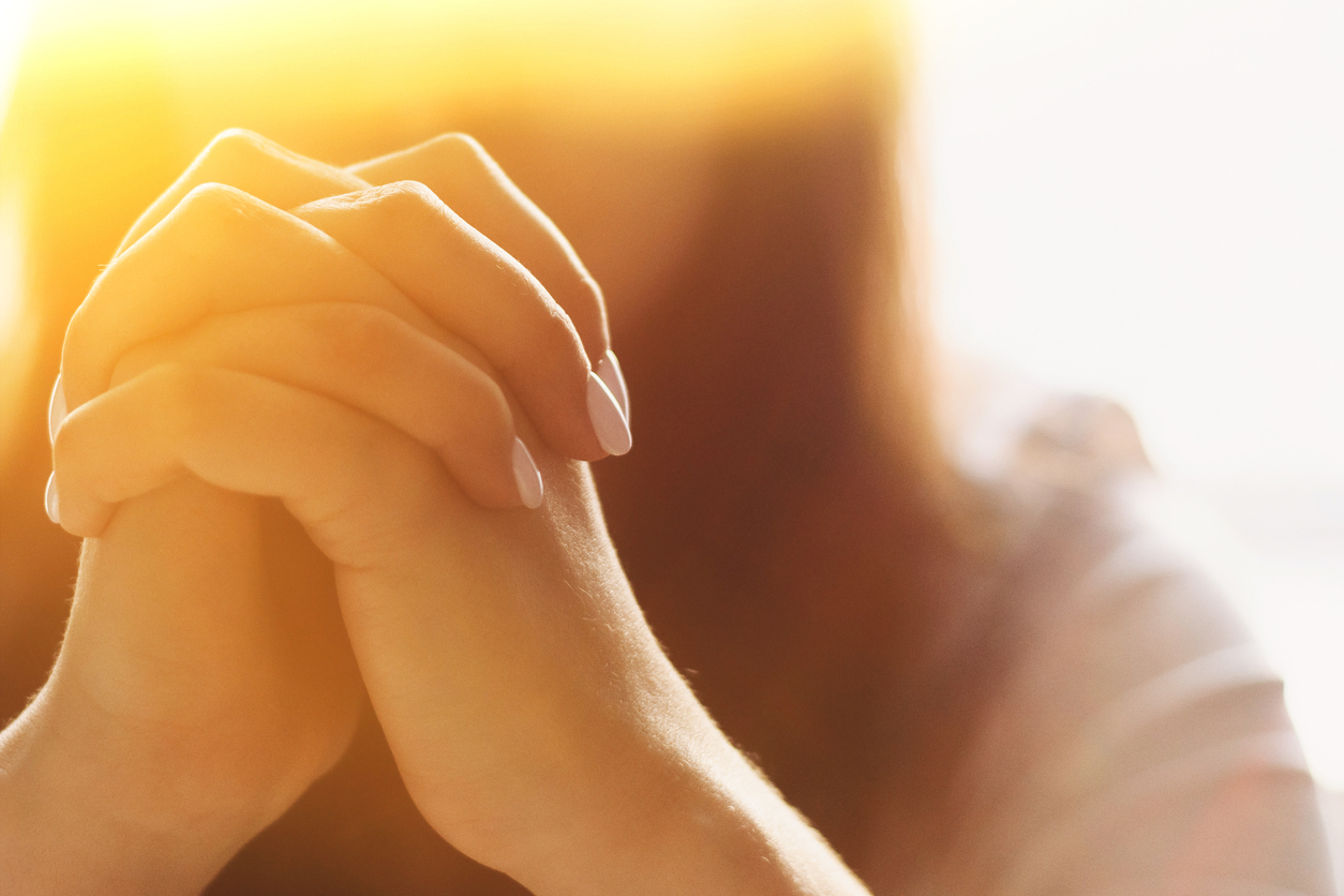 Cute beautiful girl folded her hands in prayer. A woman asks God for help