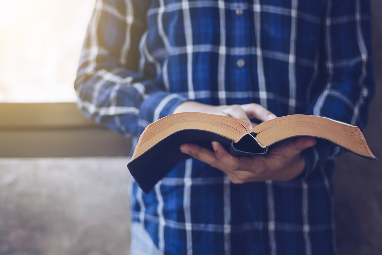 Young Christian man reading bible