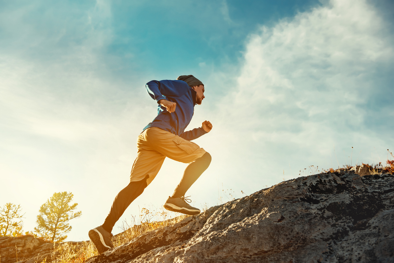 Skyrunner skyrunning crosscountry concept with young athlete on big rock