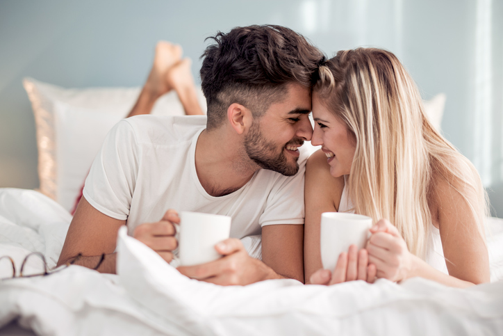 Sweet young couple lying in bedroom