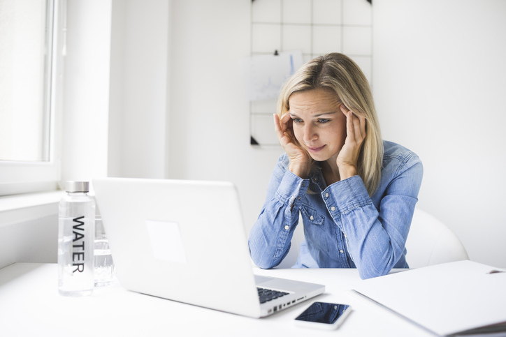 Overworked and frustrated young woman with headache