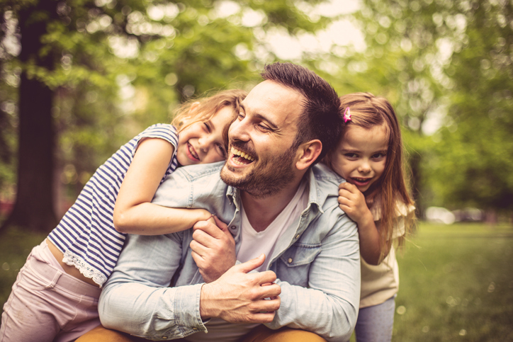 Father with daughters at park.