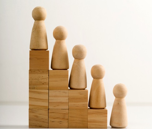 Wooden figures stand on the cubes that represent the stairs.